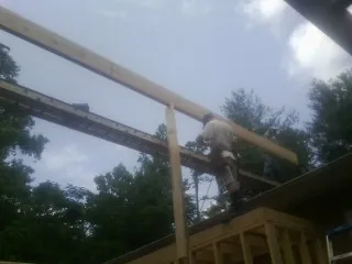 Carpenter setting a ridge beam over a new addition frame — Ice Dam Removal by Roofing Brothers in Marion
